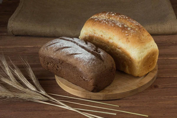 ears of rye and corn bread on a wooden Board and sacking