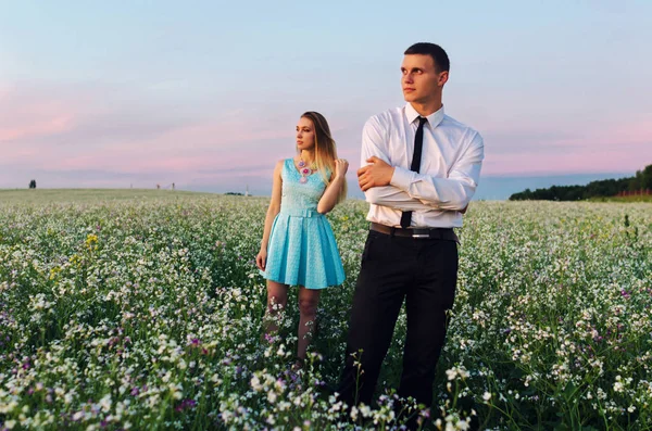 Romantic couple running in field holding hands. Couple enjoying