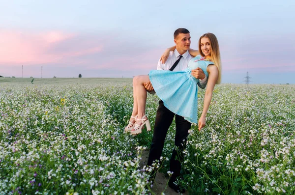 Romantic couple running in field holding hands. Couple enjoying