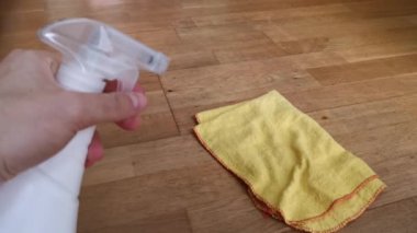 Coronavirus için dezenfeksiyon ve katın temizlenmesi. Corona virüsünün COVID-19 'un yayılmasını önlemek için ev ofisinden ya da mutfaktan ev temizleyicisi sprey şişesi ile dezenfekte ediliyor.