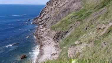 Bitkilerle dolu bir uçurum ve Cantabrian okyanusunda erişimi olmayan bir koy.