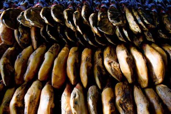 whole slabs of iberian ham hangig in deli shop in andalusia, spain