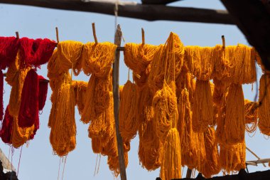 Boyanmış yün demetleri Marakeş 'in boyacıları çarşısında, Fas' ta kurumak üzere asılıyor.