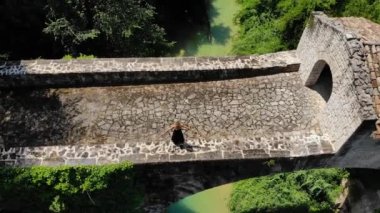 İtalyan Ascoli Piceno 'daki eski köprüde duran sarışın kız.