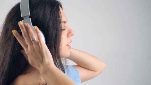 Een vrouw in een koptelefoon die muziek luistert — Stockvideo