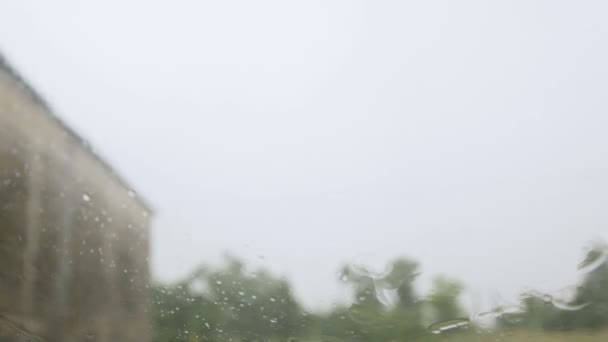 Está a chover. chuva cai sobre o vidro do carro — Vídeo de Stock