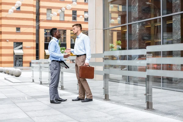 Two businessmen talking and looking at documents — Stock Photo, Image