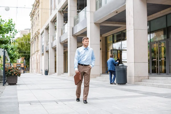 Homem de negócios caminha com pasta — Fotografia de Stock