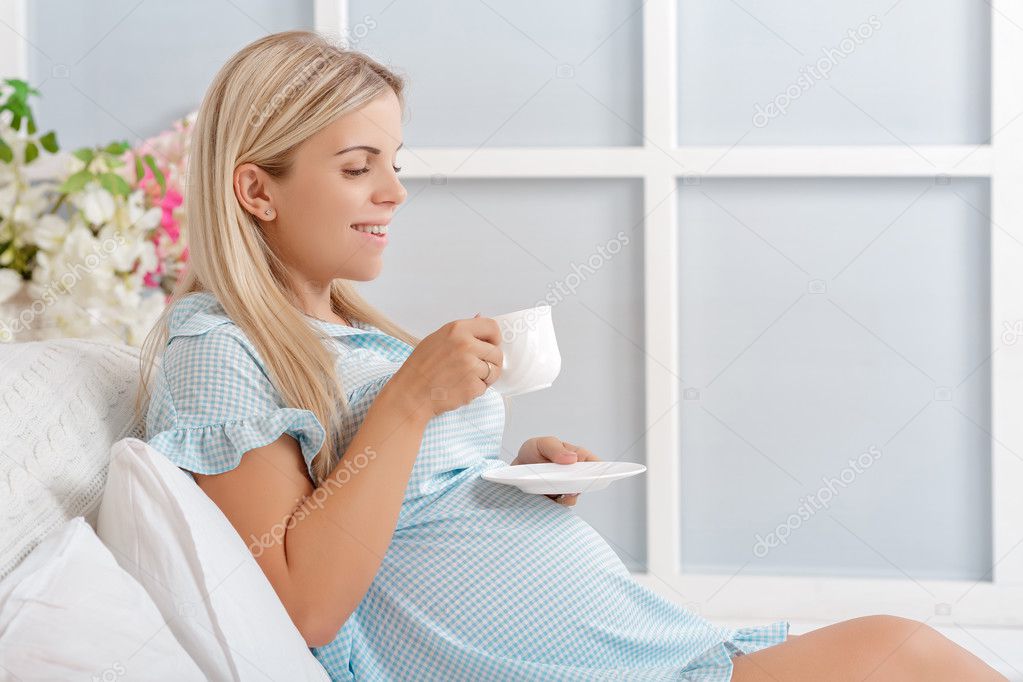 young pregnant woman drinking tea 