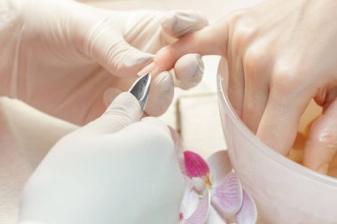 Manikürcü profesyonel manikür aracı kullanır.