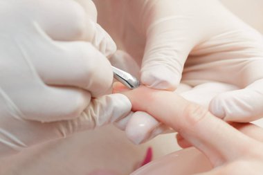 Manikürcü profesyonel manikür aracı kullanır.