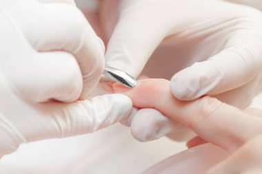 Manikürcü profesyonel manikür aracı kullanır.