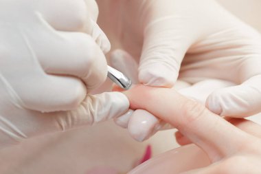 Manikürcü profesyonel manikür aracı kullanır.