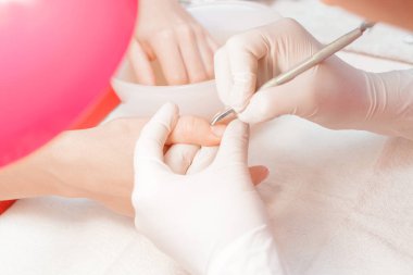 Manikürcü profesyonel manikür aracı kullanır.