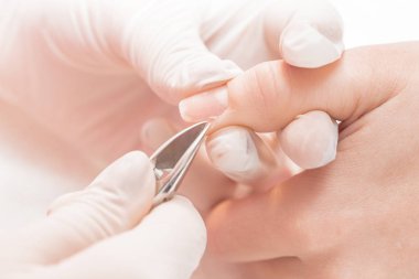 Manikürcü profesyonel manikür aracı kullanır.