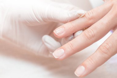 Manikürcü profesyonel manikür aracı kullanır.