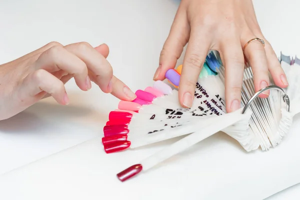 Menina escolhe a cor do polonês da manicura . — Fotografia de Stock