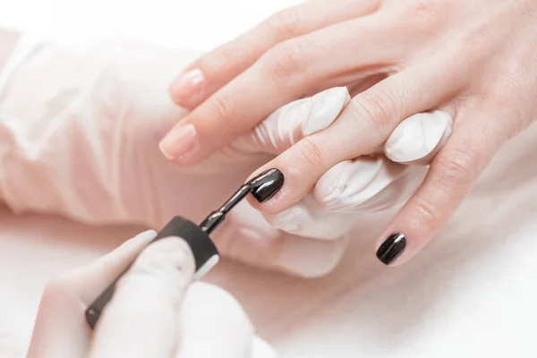 Esteticista aplicando uñas polacas a las mujeres — Foto de Stock