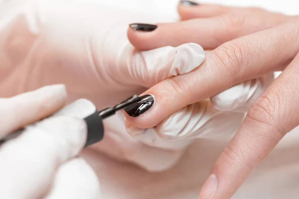 Esteticista aplicando uñas polacas a las mujeres — Foto de Stock