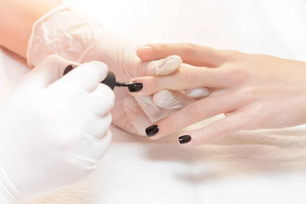 Esteticista aplicando unhas polonesas para mulheres — Fotografia de Stock