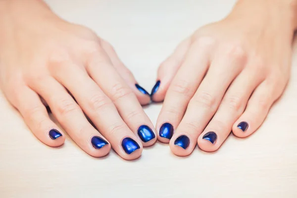 Mãos femininas com unha azul polonês, close-up — Fotografia de Stock