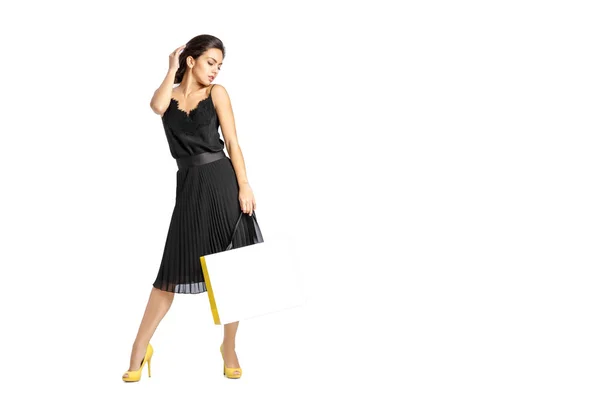 Sexy vrouw in zwarte jurk met shopping tassen — Stockfoto