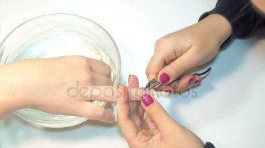 Manikürcü profesyonel manikür aracı kullanır.