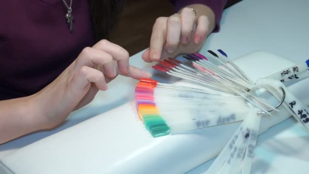 Menina escolhe a cor do polonês da manicura. testadores prego polonês — Vídeo de Stock