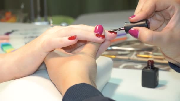 Beautician applying Polish nails to women nails — Stock Video