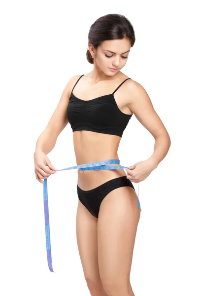 Mujer midiendo su cintura por cinta métrica azul — Foto de Stock