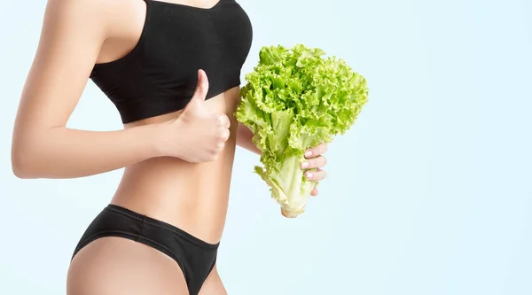 Femme saine avec des feuilles de salade — Photo
