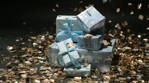 Gold confetti falling on blue gifts boxes — Stock Video