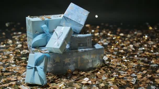 Gouden confetti vallen op de giften van de blauwe dozen — Stockvideo