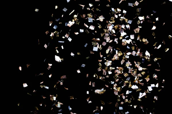 Confete dourado sobre fundo preto — Fotografia de Stock