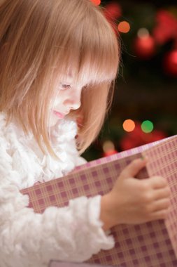 küçük gülümseyen kız sihirli bir Noel hediye kutusu açar