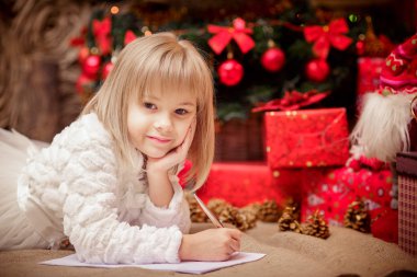 küçük kız Noel Baba'ya bir mektup yazar