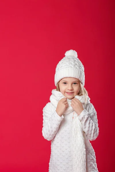 Uśmiechający się blond dziewczynka w biały kapelusz i szalik na czerwone liczby — Zdjęcie stockowe