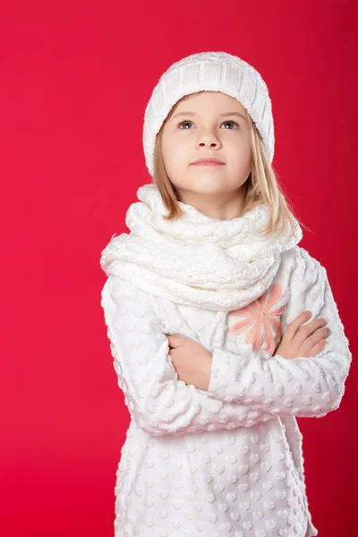 Petite fille blonde souriante dans un chapeau blanc et écharpe sur fond rouge — Photo