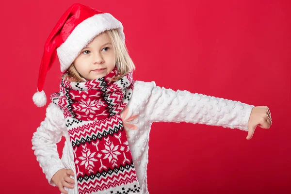 Little girl in santa hat and scarf on red background — Stock Photo, Image