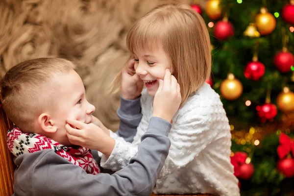 Zwei kleine Kinder im Hintergrund des Weihnachtsbaums — Stockfoto