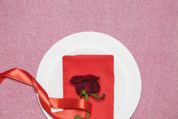 Rode roos met lint op plaat witte achtergrond. — Stockfoto