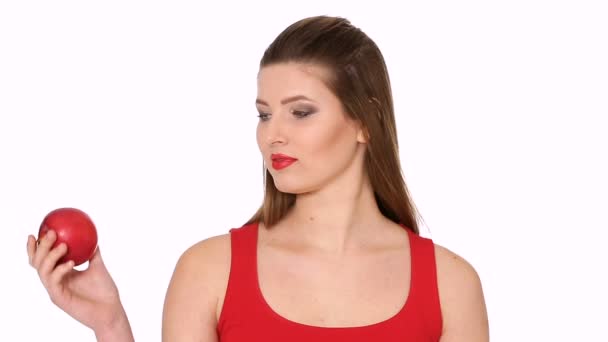 Mujer sosteniendo manzana roja y sonriendo sobre fondo blanco — Vídeo de stock