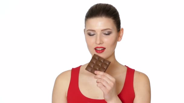 Mujer con lápiz labial rojo come chocolate negro — Vídeos de Stock