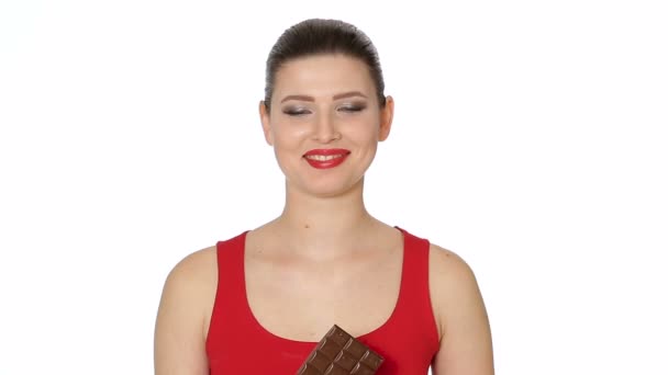Kvinna med rött läppstift äter mörk choklad — Stockvideo
