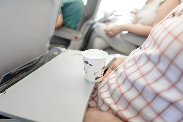 Mann trinkt Kaffee im Flugzeug. — Stockfoto