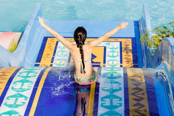 Vrouw die naar beneden een waterglijbaan — Stockfoto