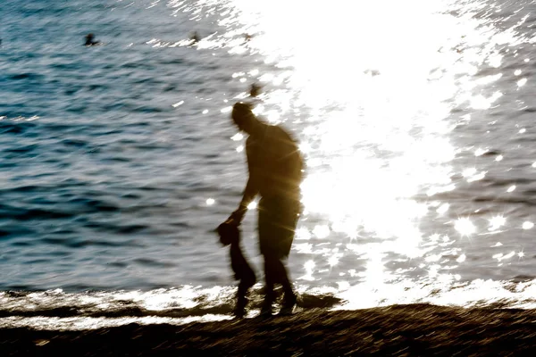 模糊的背景在海岸的人剪影 — 图库照片