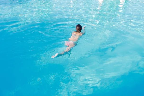 Γυναίκα που κολυμπούσαν σε μια πισίνα με μπλε νερό — Φωτογραφία Αρχείου