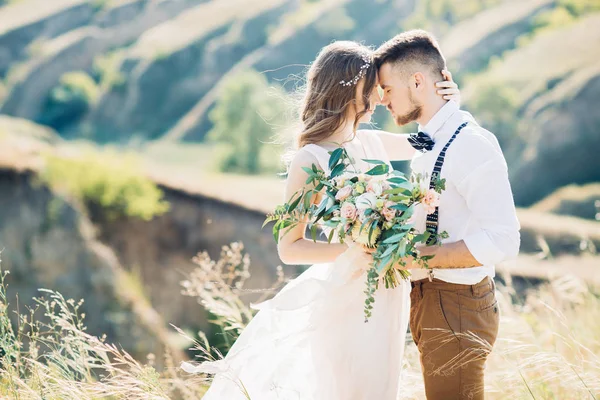 Braut und Bräutigam umarmen sich bei der Hochzeit in der Natur. — Stockfoto