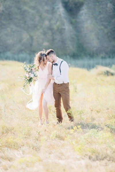 Bruden och brudgummen kramas på bröllopet i naturen. — Stockfoto